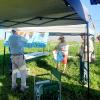 Tom putting sponsor posters up while Henry and Mike Kelly assist.